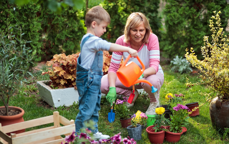 child and woman watering flowers