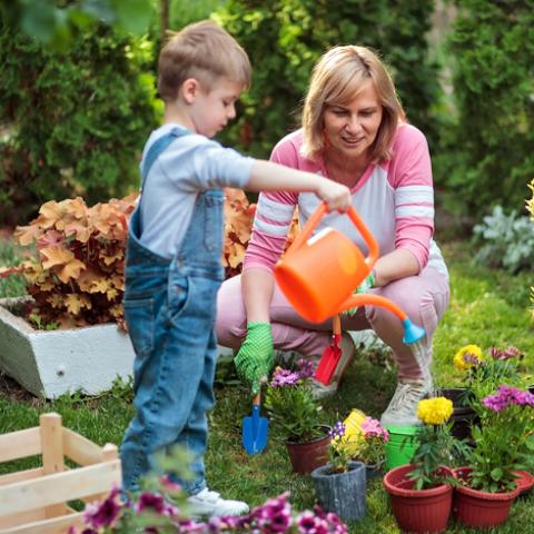 child and woman watering flowers